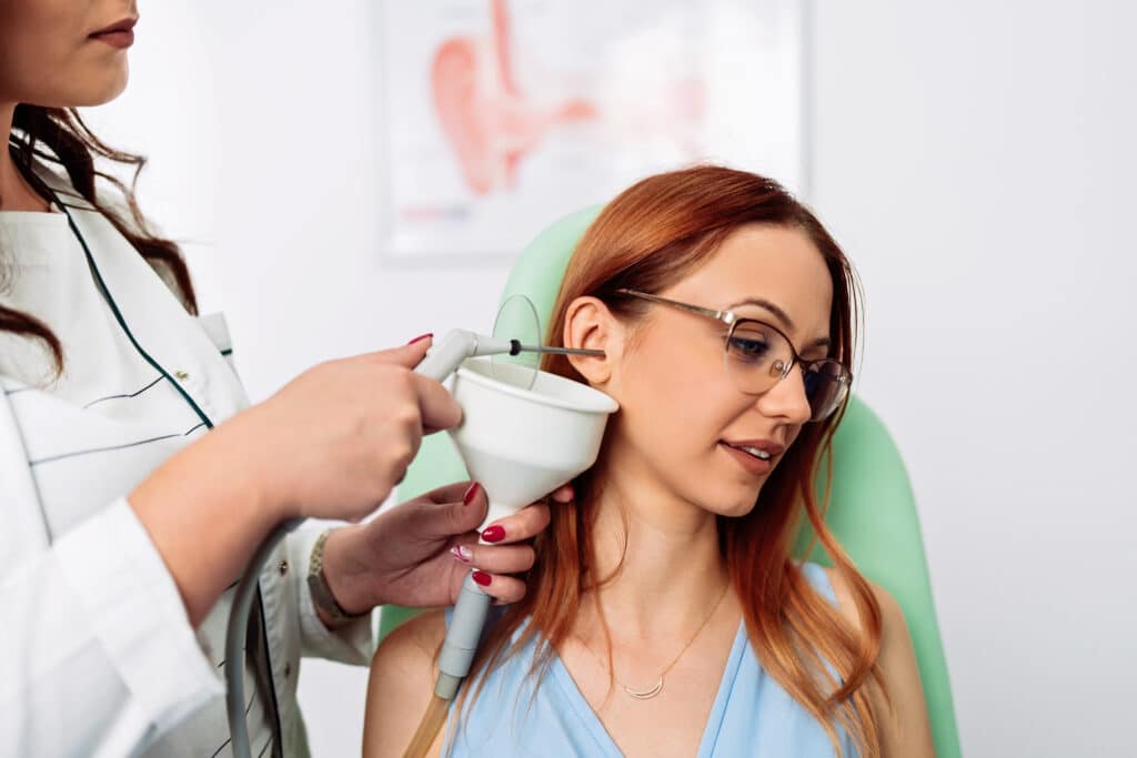 Woman getting her ear wax removed safely by an audiologist